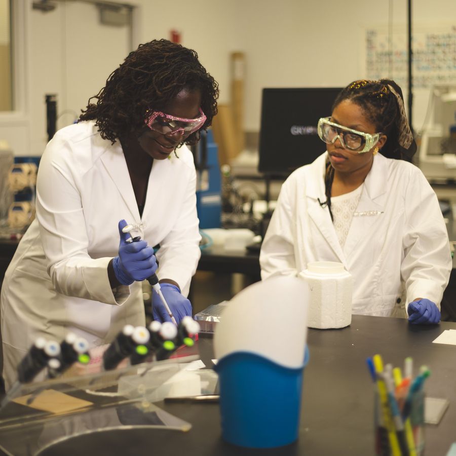 Dr. Raven Baxter pipetting at the bench in a research lab